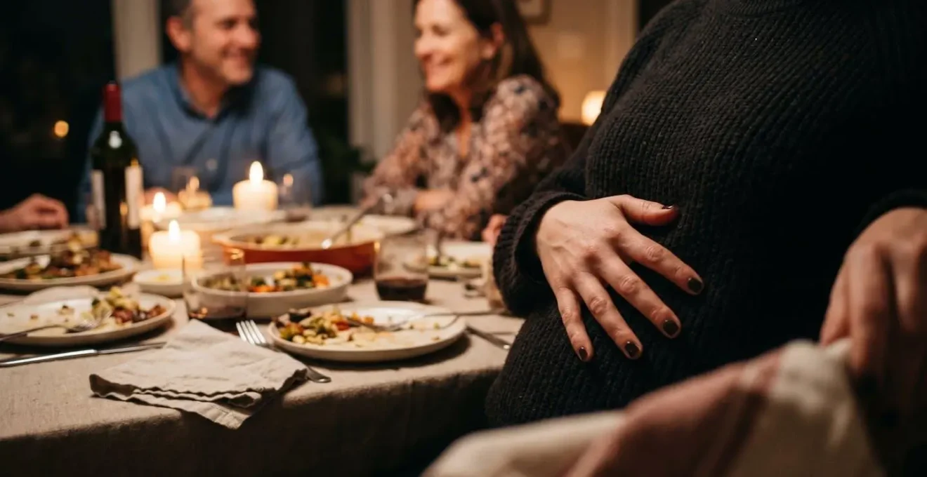 Convive souriant posant délicatement sa main sur son ventre lors d'un repas familial chaleureux