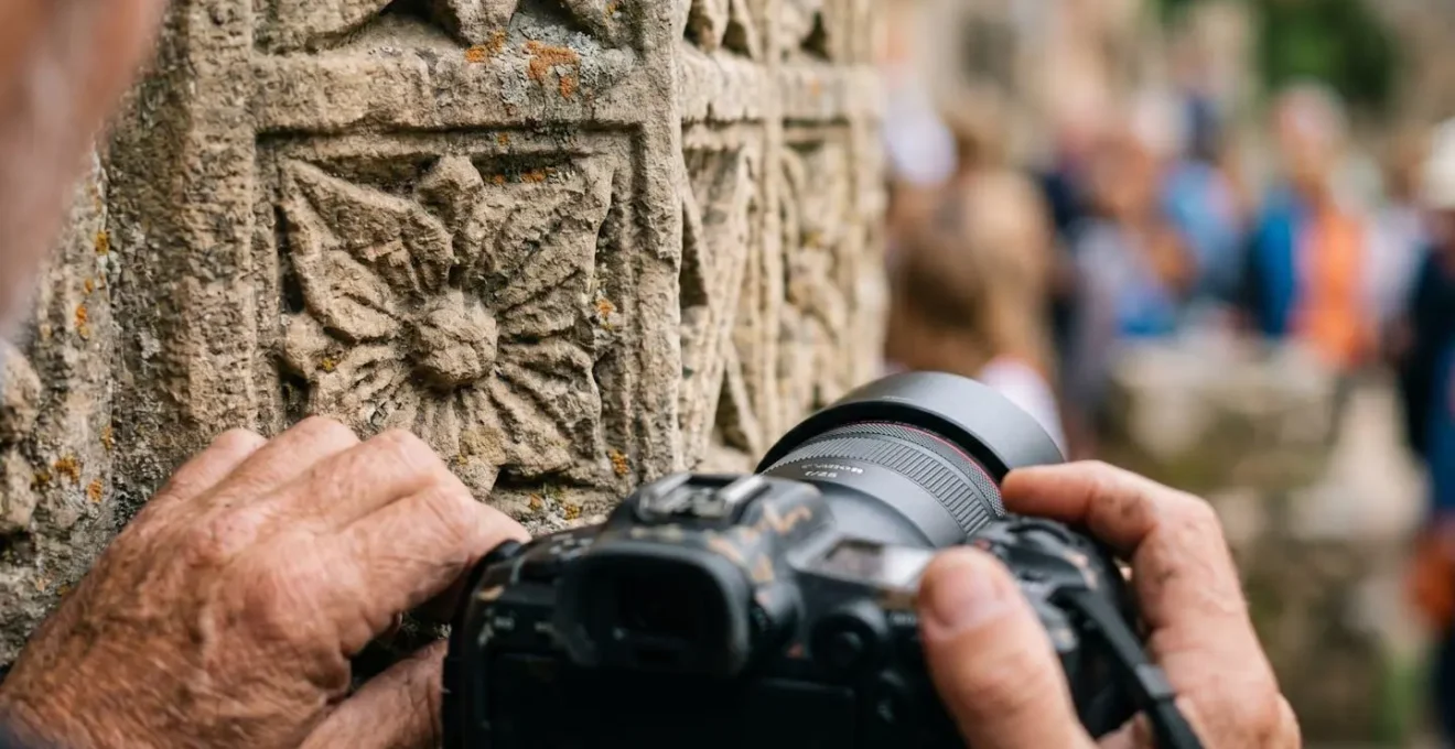 Photographe accroupi capturant un détail architectural en gros plan avec un appareil photo